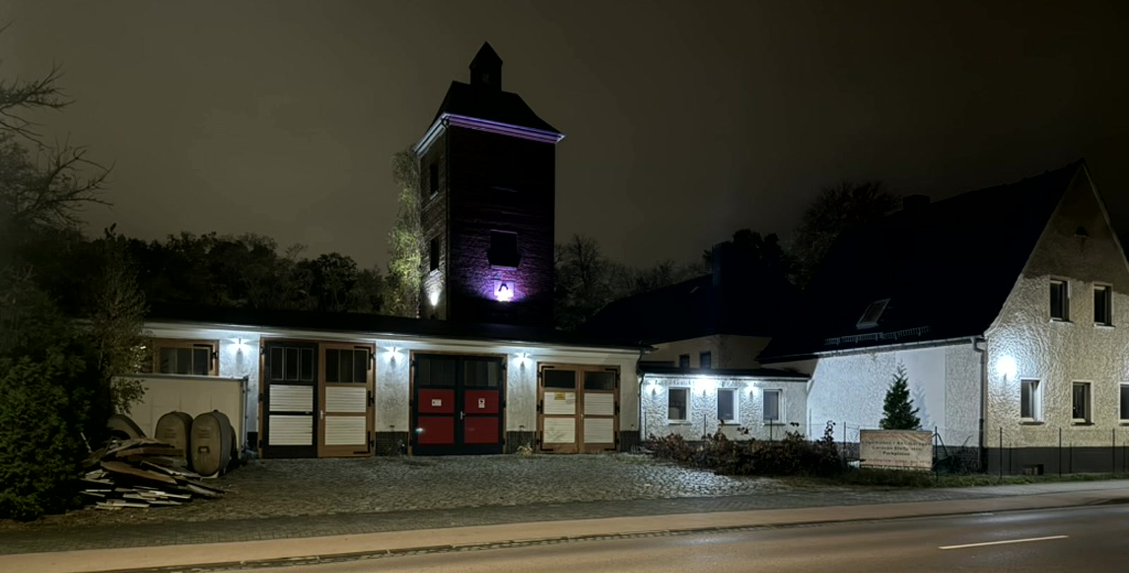 Die Alte Feuerwache Wolfen heute, abends mit angestrahltem Turm